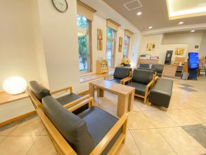 - une salle d'attente avec des canapés, des chaises et une table dans l'établissement Hotel Route-Inn Hon Hachinohe Ekimae, à Hachinohe