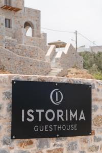 een bord op een muur voor een gebouw bij Istorima Guesthouse in Gythio