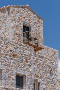 een stenen gebouw met een balkon erboven bij Istorima Guesthouse in Gythio