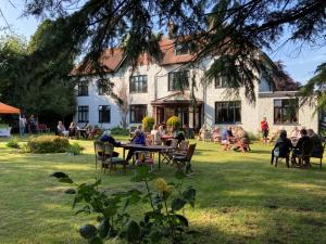 un gruppo di persone seduti a un tavolo di fronte a un edificio di The Nyton Guesthouse a Ely