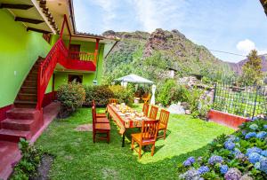 een tafel en stoelen in de tuin van een huis bij Happy Land Valle Sagrado in Urubamba