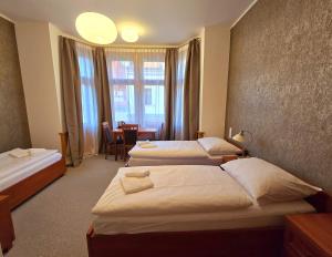 een hotelkamer met 2 bedden en een tafel bij Kafka Prague rooms in Praag