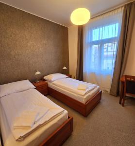 2 bedden in een hotelkamer met een raam bij Kafka Prague rooms in Praag