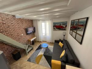 sala de estar con sofá y pared de ladrillo en Appartement neuf à Palaiseau !, en Palaiseau