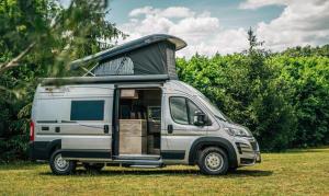 een zilveren camper geparkeerd in een veld bij Ljetna bašta "LISIN"Bradina Konjic in Konjic