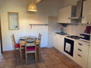 a kitchen with a table and chairs and a kitchen with a stove at Casa Express tra Como e Milano in Saronno