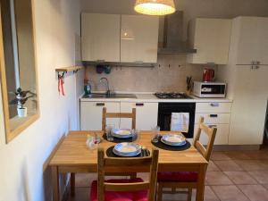 a kitchen with a wooden table with four chairs and a tableablish at Casa Express tra Como e Milano in Saronno