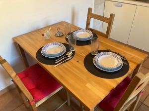 a wooden table with plates and utensils on it at Casa Express tra Como e Milano in Saronno