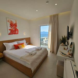 1 dormitorio con 1 cama y vistas al océano en Ares Beachfront Luxury Rooms, en Sarandë