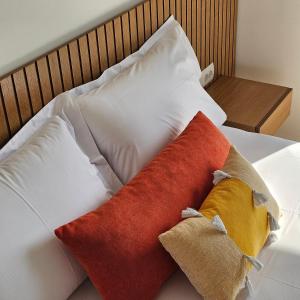 2 almohadas sentadas encima de una cama en Ares Beachfront Luxury Rooms, en Sarandë