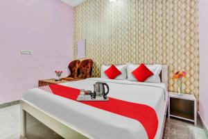 a bedroom with a large bed with red pillows at Hotel O K D Guest House in Manesar