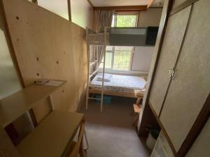 Piccola camera con letto a castello e finestra. di Guesthouse Oomiya base 大宮基地別荘 a Chiba