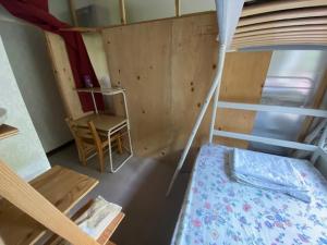 Camera piccola con letto a castello e sedia di Guesthouse Oomiya base 大宮基地別荘 a Chiba