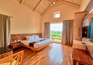 een slaapkamer met een groot bed en een groot raam bij AJ Gable Clouds Ooty by VOYE HOMES - Serene Stay Near Avalanche Emerald Lake in Ooty