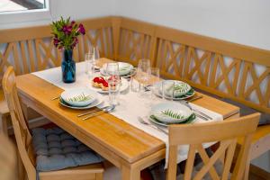 una mesa con platos y vasos y un jarrón de flores en Zur Stadtmama, en Endingen am Kaiserstuhl