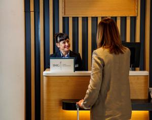 a woman standing next to a man at a counter at Hotel Logroño in Logroño