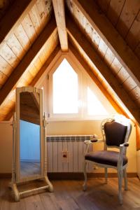 a room with a chair and a mirror in a attic at Residence La Corte in Vezza dʼOglio