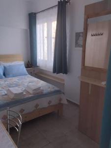 1 dormitorio con cama con espejo y ventana en Sweet Home, en Egio