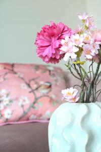 um vaso cheio de flores rosas e brancas sobre uma mesa em Traunseeresidenzen em Gmunden