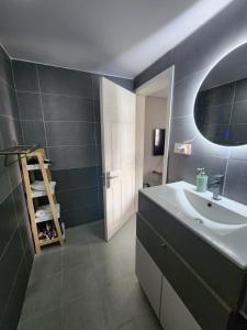 a bathroom with a sink and a mirror at Luxury Apartment 150 m from the beach in Flic-en-Flac