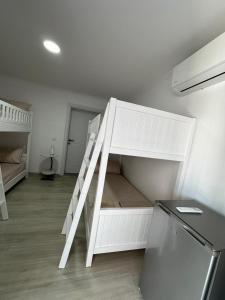 um beliche branco num quarto em Aral Hostel em Berati