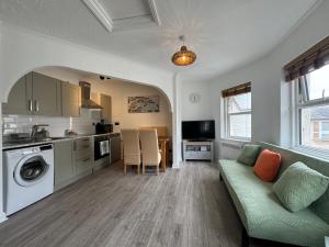 uma sala de estar com um sofá e uma cozinha em Purbeck Inn Entire Apartment in Bournemouth town centre em Bournemouth