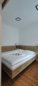 a white bed in a room with a wooden floor at HANESI apartments Luhačovice in Luhačovice