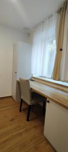 a room with a desk with a chair and a window at HANESI apartments Luhačovice in Luhačovice