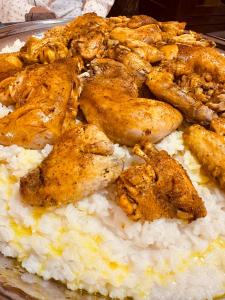 une assiette de nourriture avec du poulet et du riz dans l'établissement Dreams beach hostel, à Dubaï