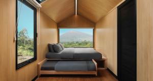 a bedroom with a bed and a large window at Bobocabin Gunung Rinjani, Lombok in Sembalun Lawang