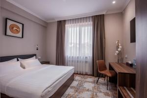 a hotel room with a bed and a desk at Silk Road Premium Hotel in Tashkent