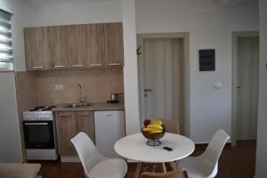 a kitchen with a table with a bowl of fruit on it at KenDar Premium Apartments in Ulcinj