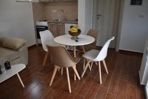 a kitchen with a table with chairs and a bowl of fruit at KenDar Premium Apartments in Ulcinj