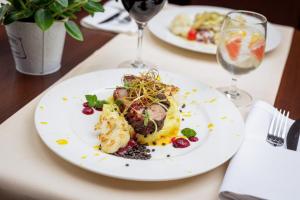 due piatti di cibo su un tavolo con bicchieri da vino di Hotel Solina Resort & Spa a Solina