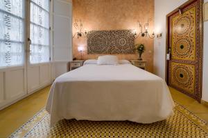 een slaapkamer met een wit bed en een groot raam bij Hotel Argantonio in Cádiz