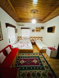 - une chambre avec 2 lits, un canapé et un tapis dans l'établissement Kore Guest House, à Gjirokastër