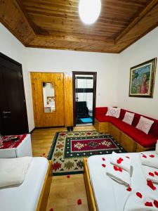 - un salon avec deux lits et un canapé rouge dans l'établissement Kore Guest House, à Gjirokastër