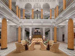 eine große Lobby mit einem Tisch und Stühlen in der Unterkunft Capital Hotel in Little Rock