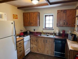 cocina con armarios de madera y nevera blanca en Casa Del Sol, en Santa Fe