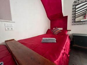 a bedroom with a red bed with a red headboard at Monte novo in Odeceixe