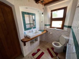 a bathroom with a sink and a toilet and a window at Monte novo in Odeceixe