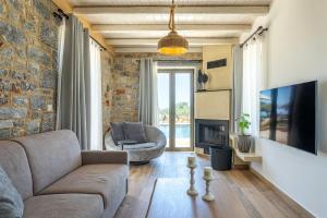 a living room with a couch and a fireplace at Lakkos Villas in Kardamili