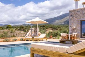 a villa with a swimming pool with a patio furniture and an umbrella at Lakkos Villas in Kardamili