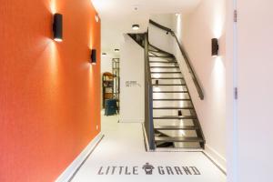 uma escada num corredor com paredes cor de laranja e branco em Little Grand em Eindhoven