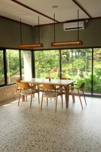 - une salle à manger avec une table, des chaises et des fenêtres dans l'établissement Citrus-House com Hotel, à Bogor