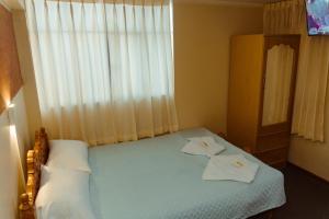 a bedroom with a bed with two towels on it at Rama Inn Hostal in Puno