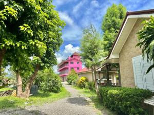 różowy dom na środku ulicy w obiekcie Fairy Story Village Farm B&B w mieście Dongshan