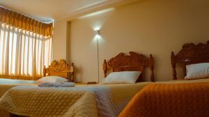 a bedroom with two beds and a window at Rama Inn Hostal in Puno