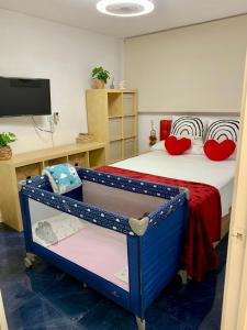 - une chambre avec un lit doté d'oreillers rouges et une télévision dans l'établissement Blue Salou, à Salou