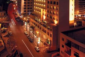 nachts eine Stadtstraße mit Autos und Gebäuden in der Unterkunft Ramada Plaza by Wyndham Beirut Raouche in Beirut